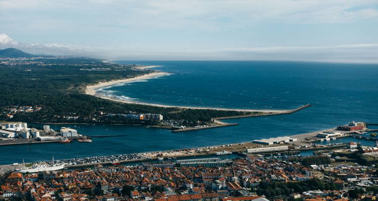 Aerial view of a coastal city with a long beach and harbor.