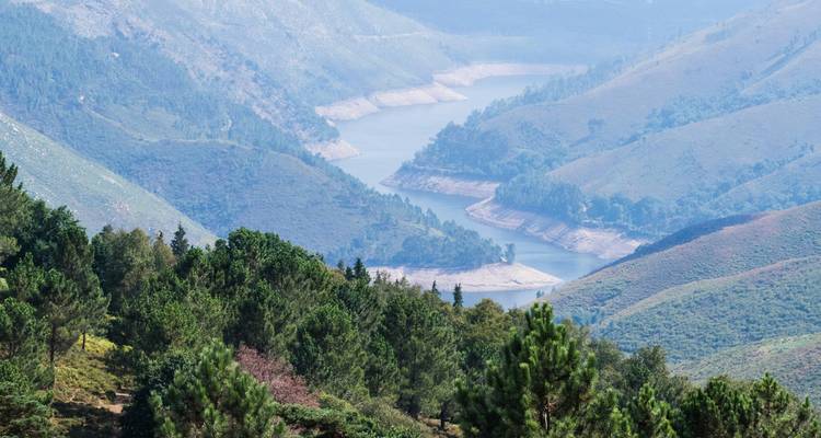 Aerial view of a winding river through forested hills.