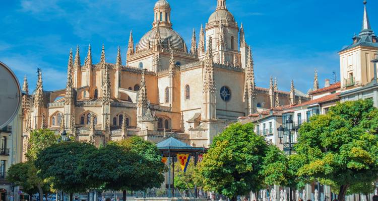 Grande cathédrale avec des motifs complexes et des flèches sur une place animée.
