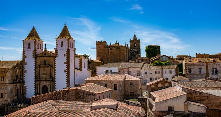 Ville historique avec églises et château sous un ciel bleu dégagé.