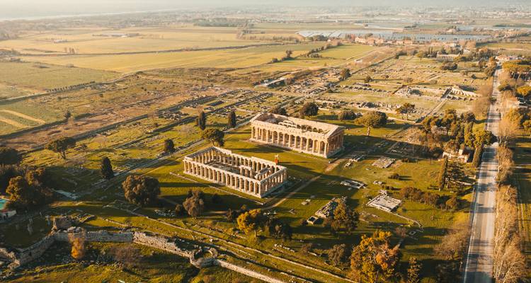 Vue aérienne de ruines antiques entourées d'une campagne luxuriante.