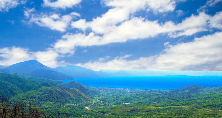 Paysage montagneux à couper le souffle avec un lac sous un ciel bleu.