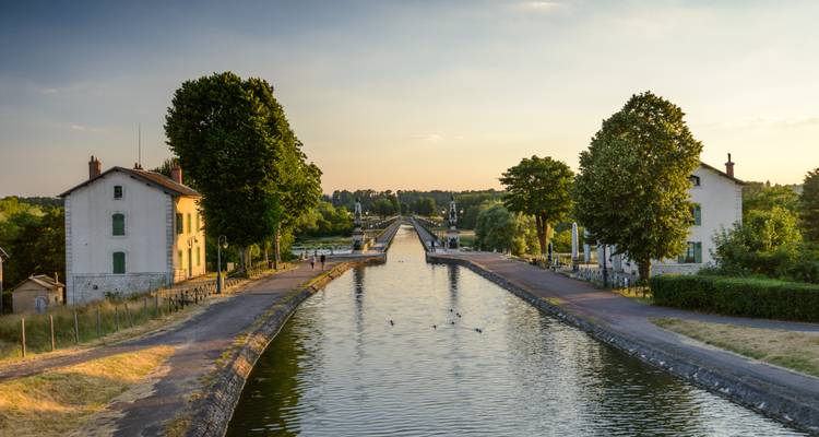 Une scène de canal avec des maisons et une voie navigable calme.