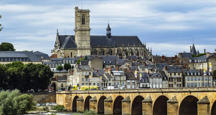 Paysage urbain historique avec une église au-dessus d'un pont.
