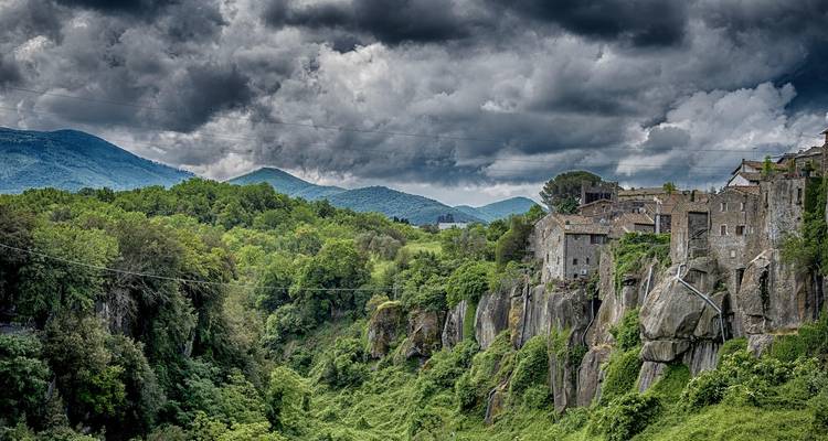 Dramatisch landschap met stormachtige luchten en een dorp.