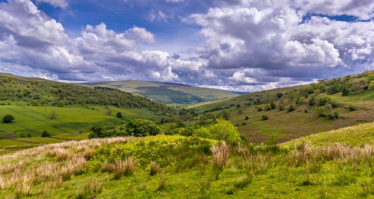 Vast green valleys under a sky with clouds.