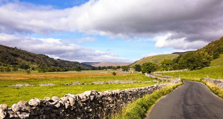 Stone walls and a road through rolling hills.