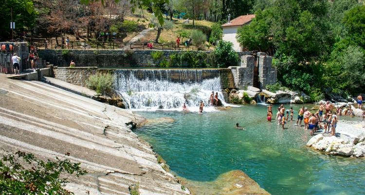 Menschen schwimmen und entspannen an einem natürlichen Gewässer.