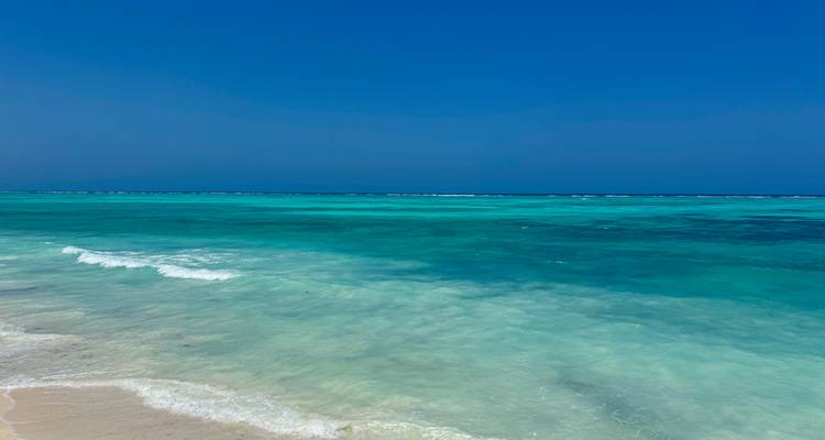 Turquoise ocean waves on a sandy shore.