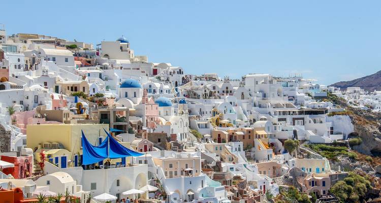 Panoramablick auf eine Küstenstadt mit traditionellen weißen Häusern, blauer Himmel.