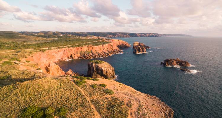 Klippen mit Blick auf das Meer bei Sonnenuntergang mit dramatischer Beleuchtung.