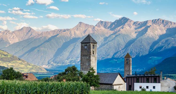 Kirchtürme mit Bergkette im Hintergrund.
