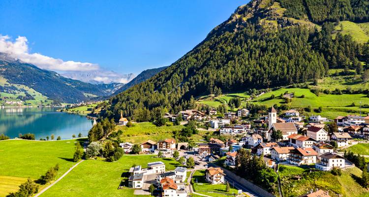 Kleine Stadt an einem See, umgeben von Bergen.