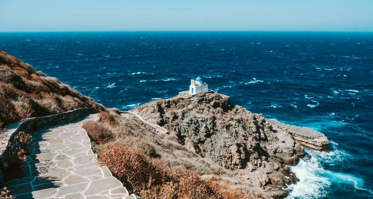 Leuchtturm auf einer felsigen Klippe mit Blick auf das Meer.