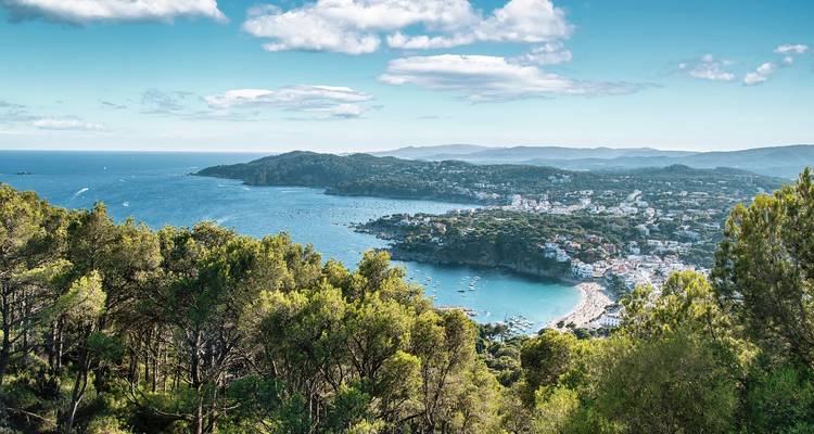 Luftaufnahme eines Küstengebiets mit einem Strand und Wohngebäuden.