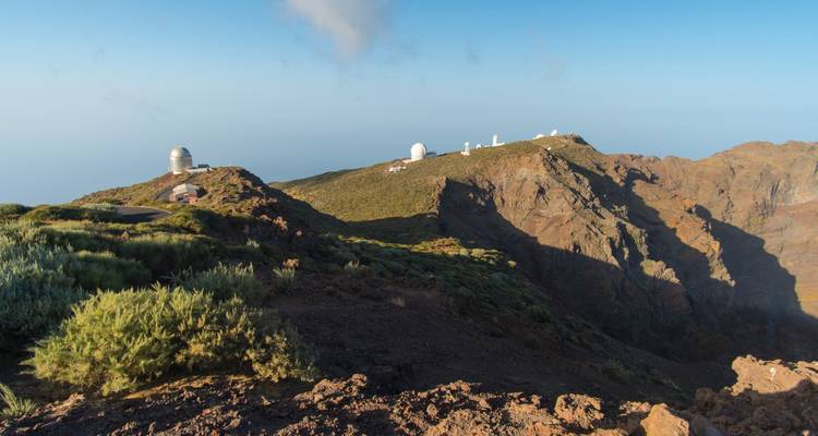Observatorios en una cresta montañosa escarpada bajo cielos despejados.