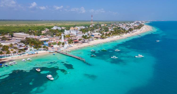 Vue aérienne d'une ville côtière avec des eaux claires et des bateaux.