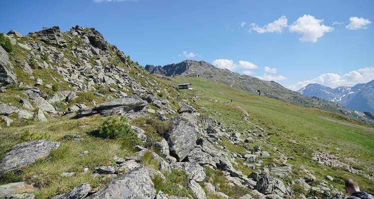 Rocky hill with a small structure and a winding path.