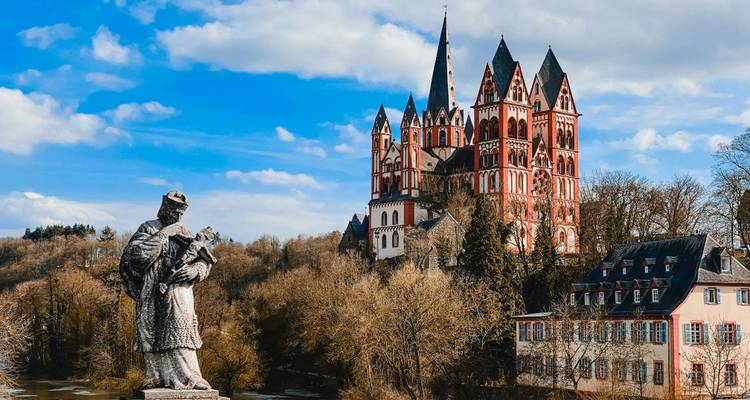 Blick auf den Limburger Dom mit Statue im Vordergrund.