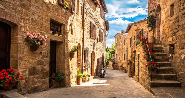 Charmante rue pavée avec des pots de fleurs en Toscane.