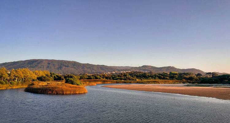 Peaceful river meander under a clear sky.