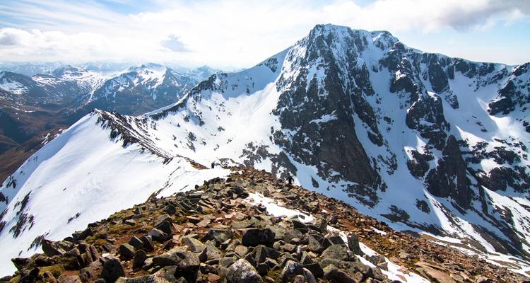Sommets montagneux enneigés sous un ciel lumineux.