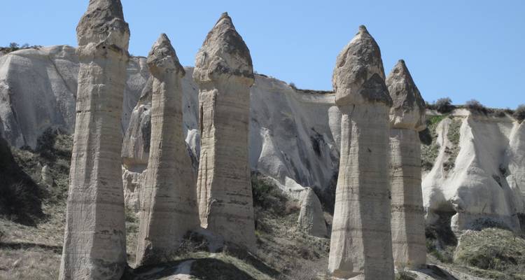Hautes tours rocheuses étroites dans un terrain accidenté.