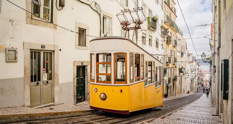 Traditionelle Straßenbahn auf einer schmalen Stadtstraße.
