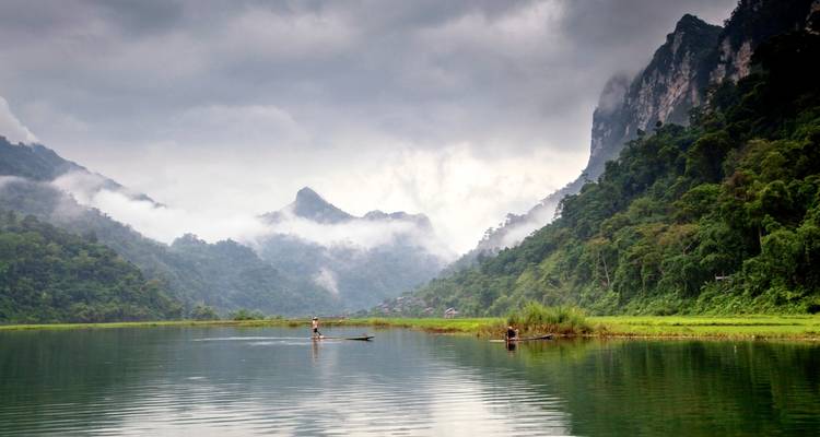 Misty mountains with a serene lake in the foreground.
