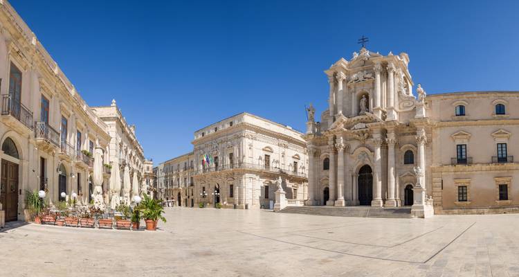 Historischer Platz mit einer markanten Kirche und umliegenden Gebäuden.