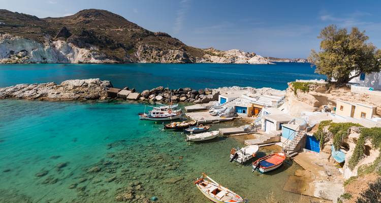 Village côtier avec de petits bateaux de pêche et une eau claire.