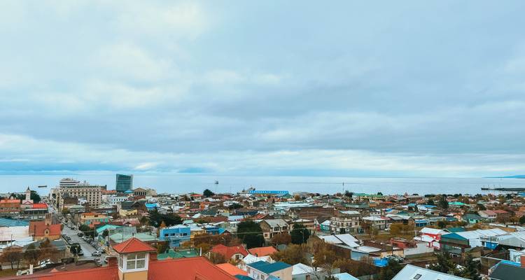 Coastal town with colorful roofs and sea in the background.