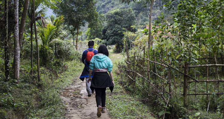 Deux personnes marchant sur un sentier forestier.