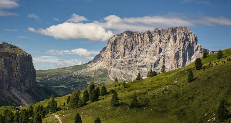 Expansive mountain landscape with green valleys and rocky peaks.