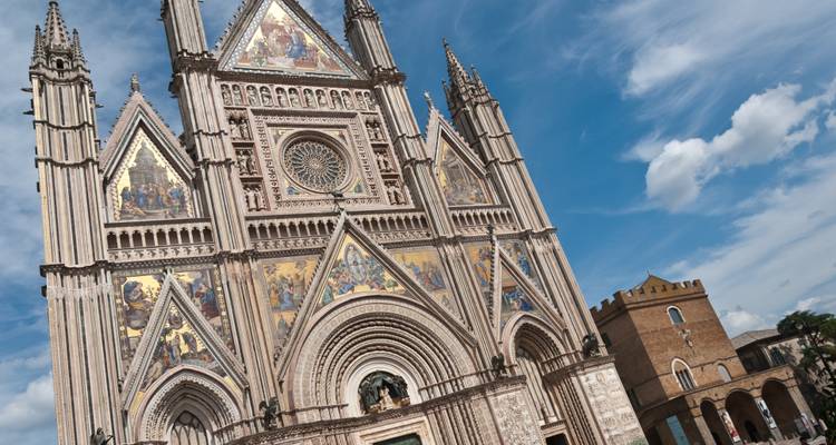 Façade élaborée de la cathédrale d'Orvieto sous un ciel bleu.