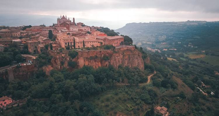 Vue panoramique d'une ville perchée avec des bâtiments historiques.