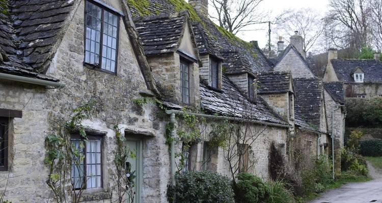 Charming stone cottages with moss-covered roofs.
