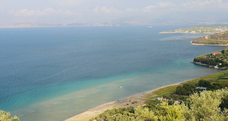 Beach with clear blue waters and a distant coastline.