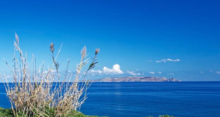 Clear blue sea with an island in the distance.