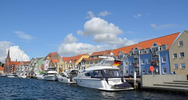 Colorful buildings along a waterfront with boats docked in the canal.
