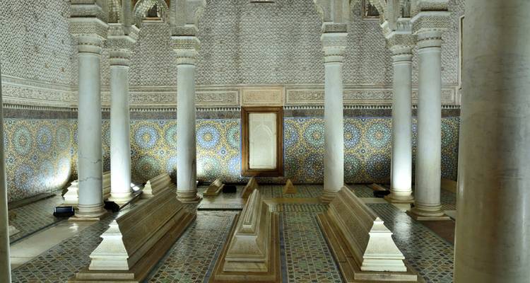 Interior intrincado de un edificio histórico marroquí con columnas y azulejos de mosaico.
