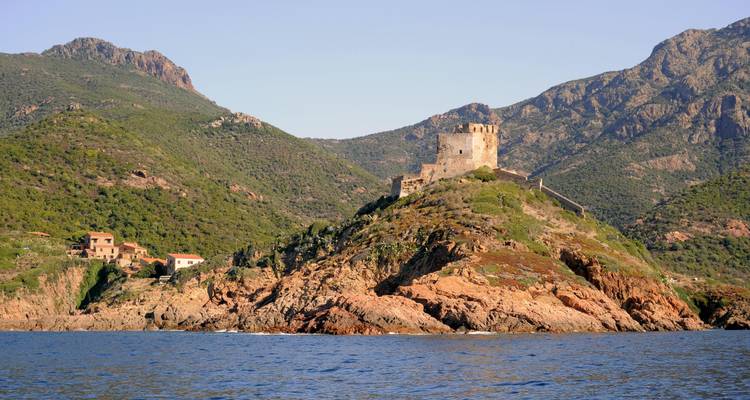 Château sur une île rocheuse entourée par l'océan.