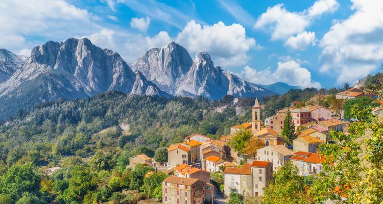 Village de montagne avec des maisons colorées et un décor montagneux pittoresque.