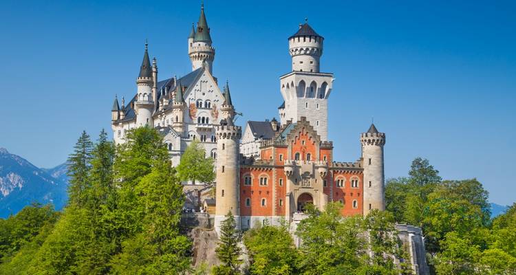 Ein berühmtes Schloss mit hohen Türmen vor einem strahlend blauen Himmel.