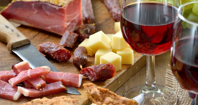 Close-up of Italian meats and wine on a wooden board.