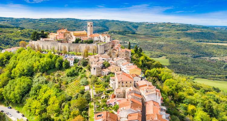 Aerial view of a hilltop town with a castle and surrounding countryside.