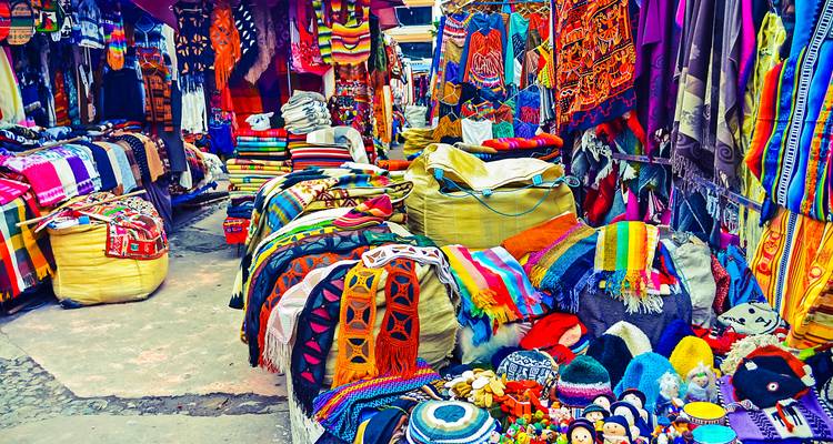 Kleurrijke textiel en ambachtswerk op een drukke markt.