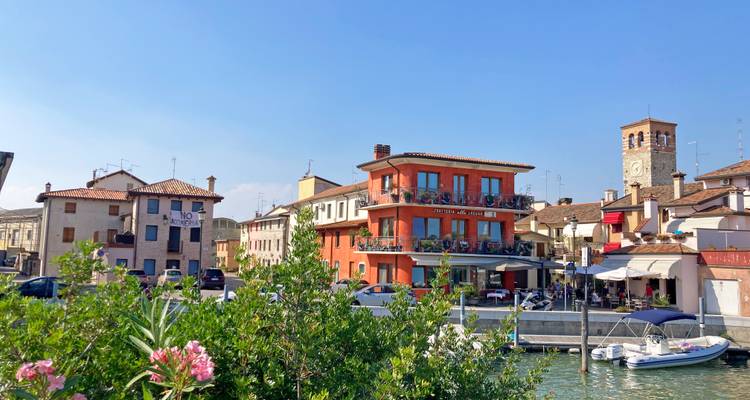 Eine lebendige Stadt am Wasser mit einem Uhrenturm und einem Restaurant.