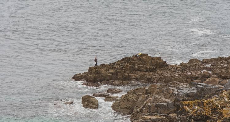 Personne debout sur une zone côtière rocheuse