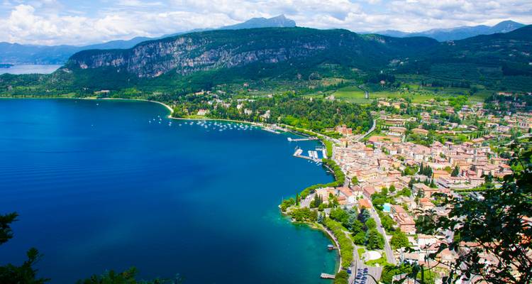 Vue aérienne d'une ville au bord d'un lac entourée de montagnes.